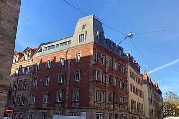 Aufstockung Nürnberg Foto einer Aufstockung aus Holz. Man sieht mehrere, hohe Gebäude.
