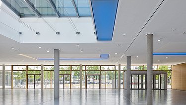 Interior photo of the Munich North Grammar School. You can see a corridor area and the timber mullion and transom façade.