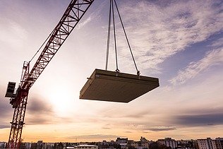 Photo of the Collegium Academicum in Heidelberg during assembly. You can see a LENO wooden element hovering on the crane.