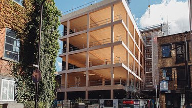 Photo of the shell of the multi-storey Black and White office building in London. You can see a building structure made of wood.