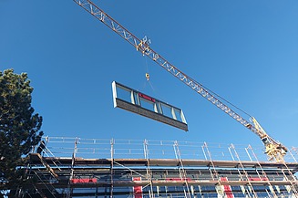 Photo of an assembly of a timber frame element. You can see a floating element on the canal.