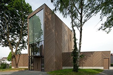 Church KGK Immanuelkirche Cologne Photo of an exterior shot of the Immanuel Church in Cologne. This has a wooden façade and a flat roof and a wooden extension on each side.