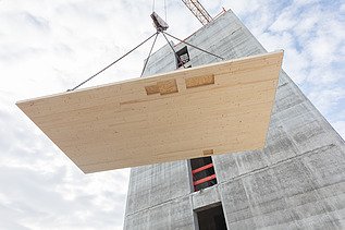 Photo of a LENO cross-laminated timber element on the crane being pulled upwards.