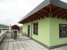 Foto eines Eckdetails eines Gebäudes mit grüner Fassade.