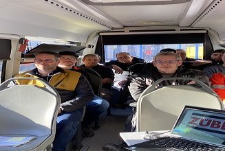 Foto von gewerblichen ZÜBLIN Timber Kollegen, die im BG BAU-Bus sitzen.