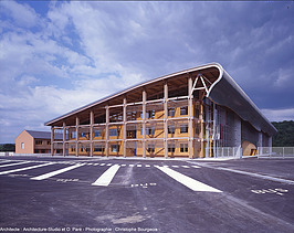 Photo of the Mirecourt school in France. You can see a large wooden building.