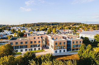Foto einer Luftaufnahme eines Holzbaukomplexes. Die Universität Witten-Herdecke  ist zu sehen.