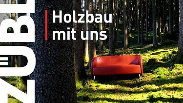 Foto einer roten Couch inmitten eines Waldes. Video Holzbau mit uns.