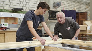 Sebastian arbeitet mit einem erfahrenen Zimmerer zusammen.