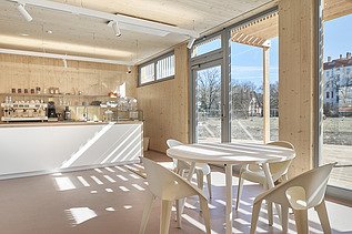 Photo of an interior with many wooden surfaces, glass front and counter.
