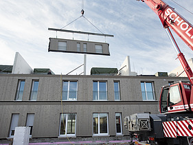 Foto der Montage von LENO-ADD-Holzbauelementen, auf der Baustelle Quartier Hangweide in Kernen