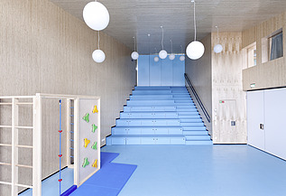 Foto des Flurbereichs des Kindergarten Ebersberg. Man sieht viele Holzoberflächen an Wänden und Decken.