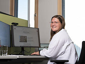 Foto einer jungen Frau am PC-Arbeitsplatz. Ausbildung Industriekauffrau:man.