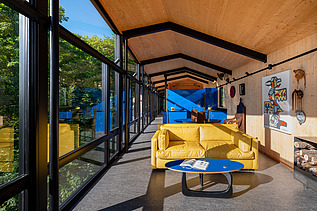 Foto eines Wohnhauses aus Holz auf Stahlpfählen, inmitten des Waldes.