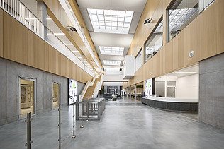 Photo of a large interior with many concrete and wooden surfaces.