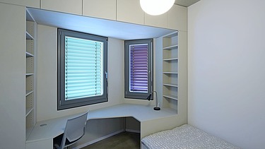 Photo of a room in the Adlershof student hall of residence in Berlin. You can see a bed and a desk.