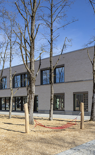Außenaufnahme der Vinzenz-Pallotti-Schule in Friedberg. Man sieht ein großes, weißes Gebäude mit Flachdach.