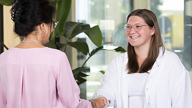 Foto von zwei Frauen, die sich die Hand geben. Ausbildung Industriekauffrau:man.