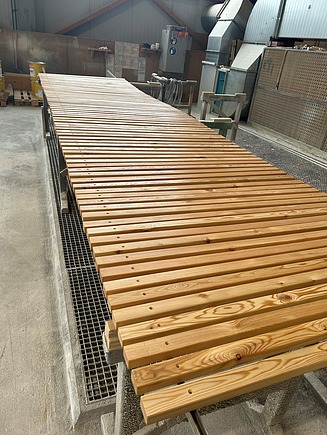 Foto von Holzteilen für Holzliegen. Sie befinden sich im Werk von ZÜBLIN Timber.