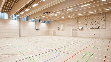 Foto der Sporthalle des Gymnasiums in Diedorf. Holzbau Halle innen.