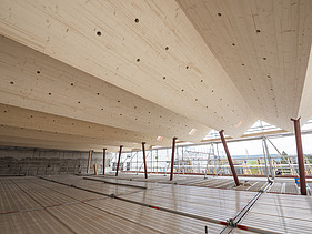 Foto einer Baustelle. Man sieht ein Faltdachwerk mit LENO-Brettsperrholzelementen