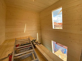 Foto eines Rohbaus aus LENO-Brettsperrholz. Man sieht viele Holzoberflächen in einem Innenraum.