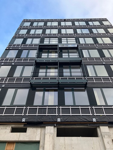Foto eines mehrgeschossigen Gebäudes mit schwarzer Fassade.