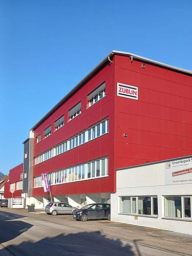 Foto eines Gebäudes mit roter Fassade. Standort ZÜBLIN Timber Gaildorf.