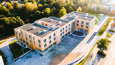 Photo of Witten University from the outside. You can see a large wooden building from a bird's eye view.
