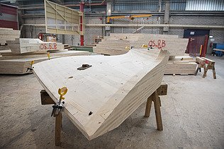 Photo of a curved LENO element in the ZÜBLIN Timber production hall.
