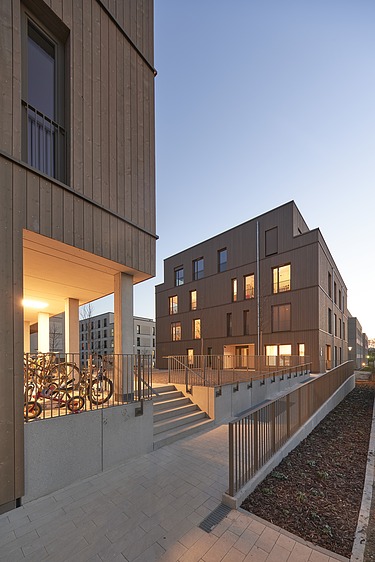 Nachtaufnahme von zwei mehrgeschossigen Gebäuden aus Holz.