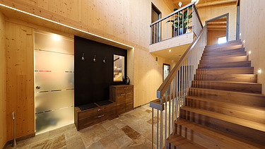 Foto eines Wohnhauses aus LENO-Brettsperrholz. Treppenhaus mit vielen Holzoberflächen.