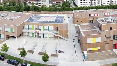 Photo of an aerial view of the Munich elementary school. You can see a large wooden building.