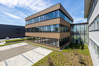 Photo of a timber building with timber and glass façade and flat roof.