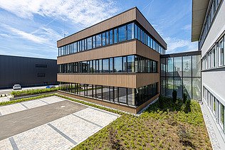 Photo of a timber building with timber and glass façade and flat roof.