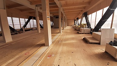 Foto eines Rohbaus aus Holz. Zu sehen sind Holzwände und Träger.