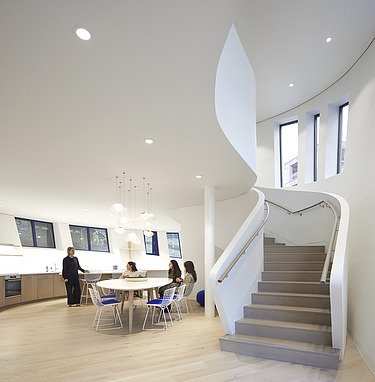 Photo of an interior with white walls and a large staircase.