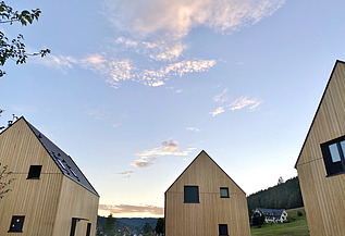 Foto des möblierten Wohnraums des Chalets Engel in Baiersbronn. Zu sehen sind drei Gebäude aus Holz.