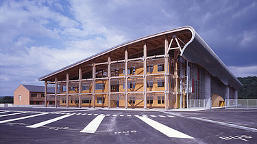 Photo of the Mirecourt school in France. You can see a large wooden building.