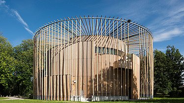 Photo of the Elizabethan Theater in Condette France. You can see a round wooden building.