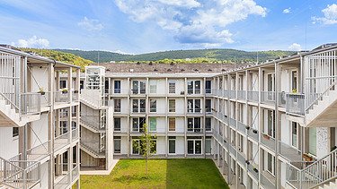 Foto des Collegium Academicums in Heidelberg. Man sieht weiße Gebäude und den Innenhof.