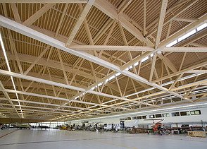 Photo of the Pilatus CH-Stans assembly hall. A large glulam roof construction can be seen.