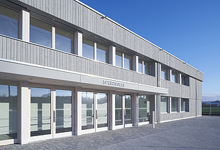 Foto der Sporthalle des Gymnasiums in Diedorf. Holzbau von außen.