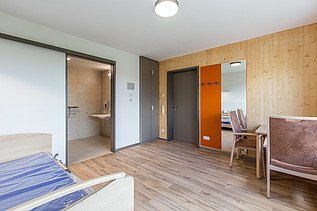 Photo of the Elias-Schrenk-Haus retirement home in Tuttlingen. You can see an interior with a wooden wall.