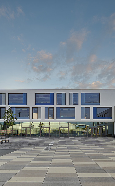 Gymnasium München-Nord Außenaufnahme des Gymnasiums München-Nord. Man sieht ein großes, weißes Gebäude mit Flachdach.