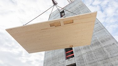 Photo of a LENO cross-laminated timber element on the crane being pulled upwards.