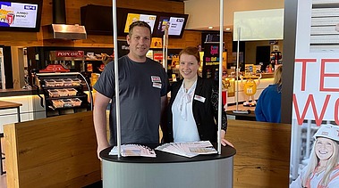 Fotos eines Messestandes von ZÜBLIN Timber. Zwei Personen sind zu sehen.