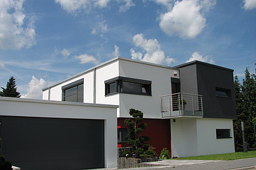 Foto eines kubischen Wohnhauses aus Holz mit Putzfassade. LENO-BSP.