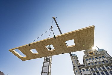 Photo of a suspended LENO cross-laminated timber element on the crane.