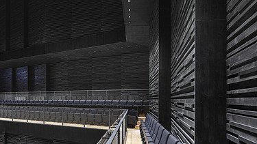 Photo of the interim venue Gasteig in Munich. You can see the black acoustic walls in the stage area.